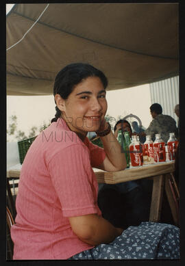 Jovem sentada á mesa.